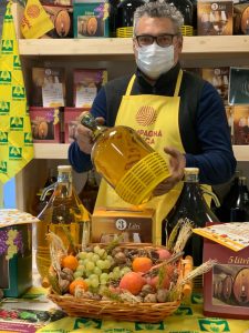 foto persona con in mano vino marchigiano, davanti tavola con prodotti vari